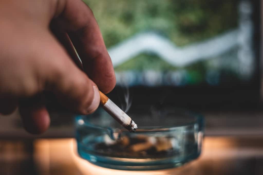 Fumeur écrasant sa cigarette dans un cendrier
